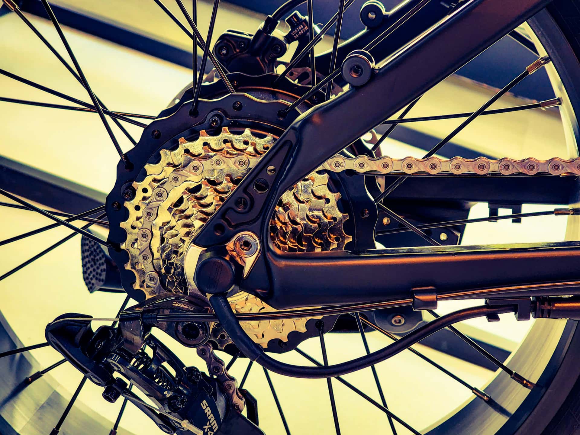A mid-drive e-bike motor and chainring seen from the drive side in hard light.