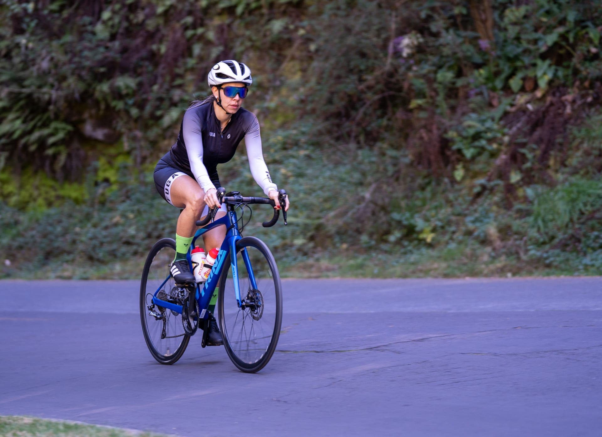 A woman riding a road bike on a country road.