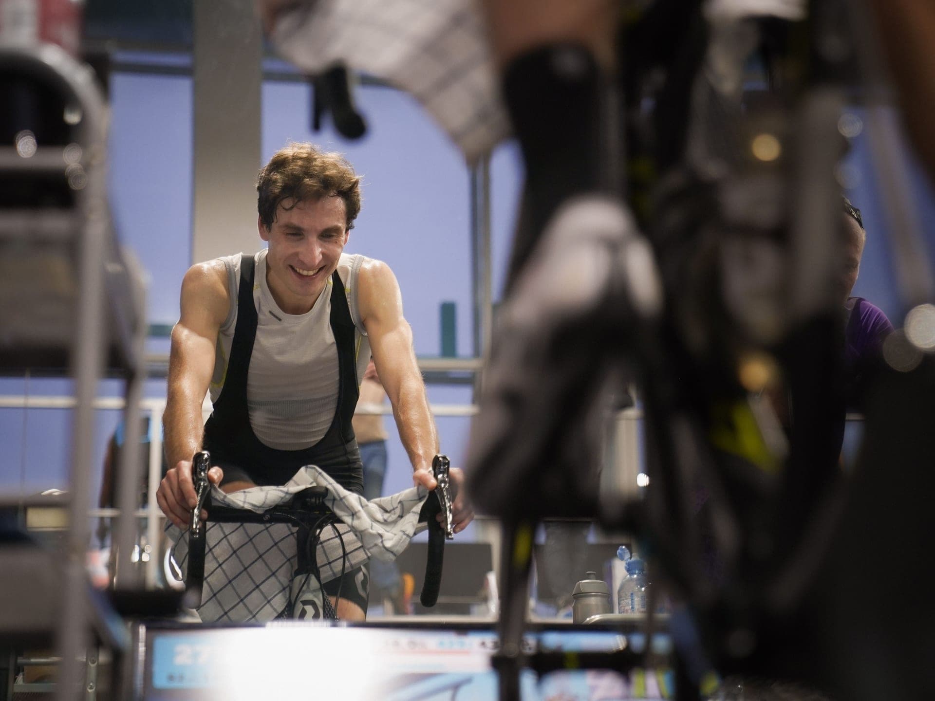 A cyclist riding a road bike mounted on an indoor trainer.