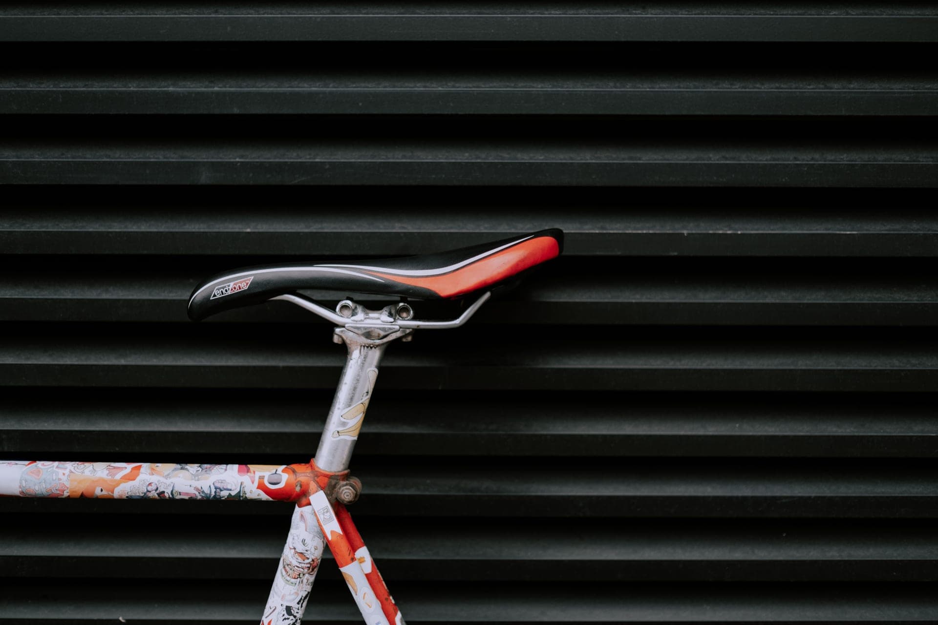 A road bike saddle photographed in profile against a plain background.