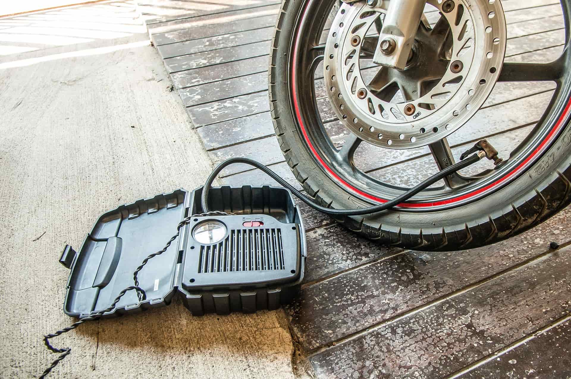 A track pump gauge reading pressure beside a road bike wheel.