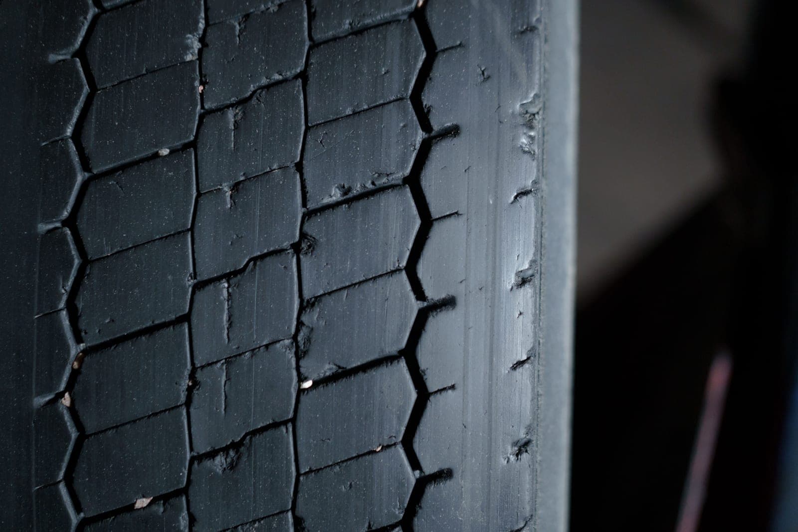 Close-up of a worn tire tread showing its grooves and wear pattern.