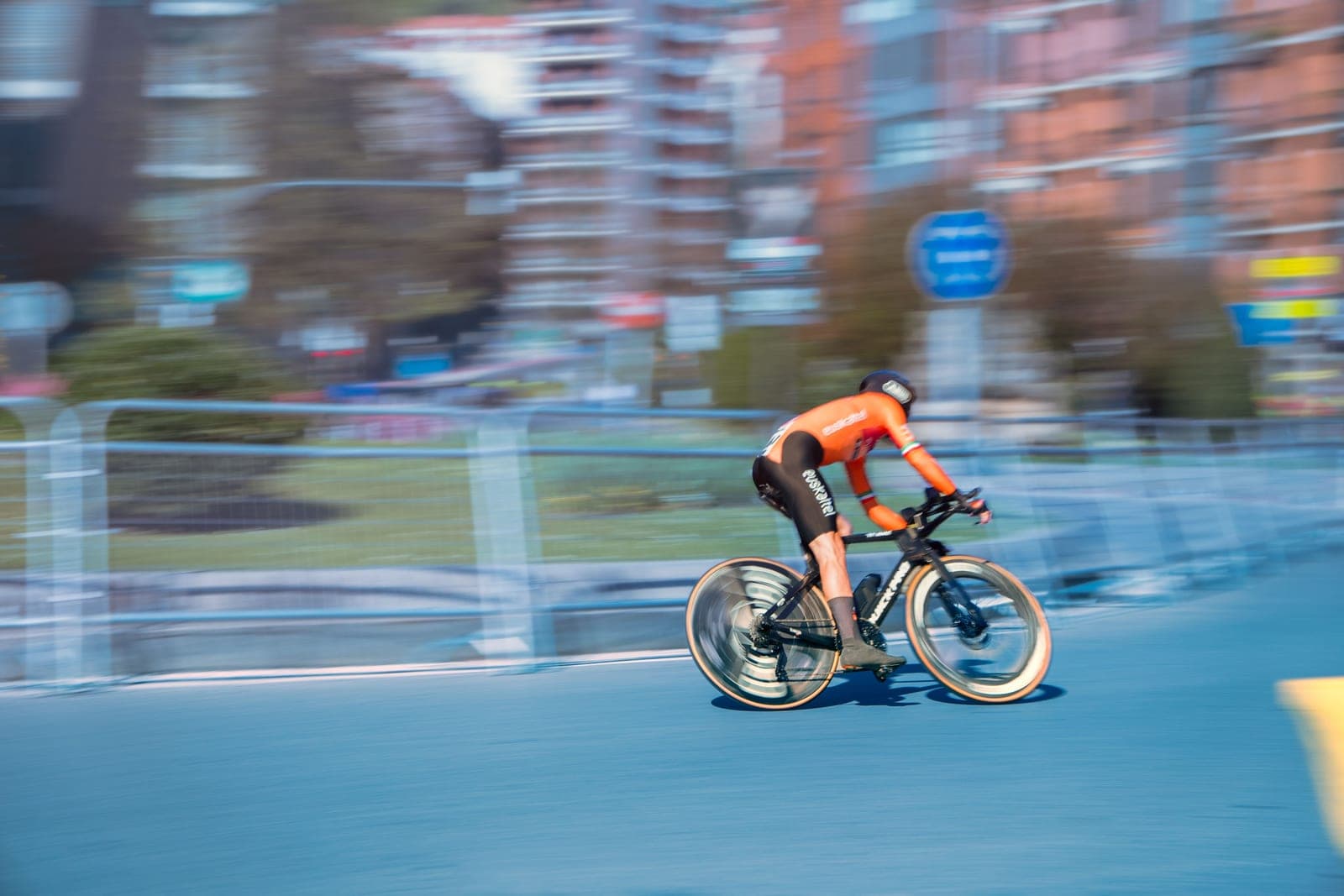 A cyclist riding at speed on a road bike.