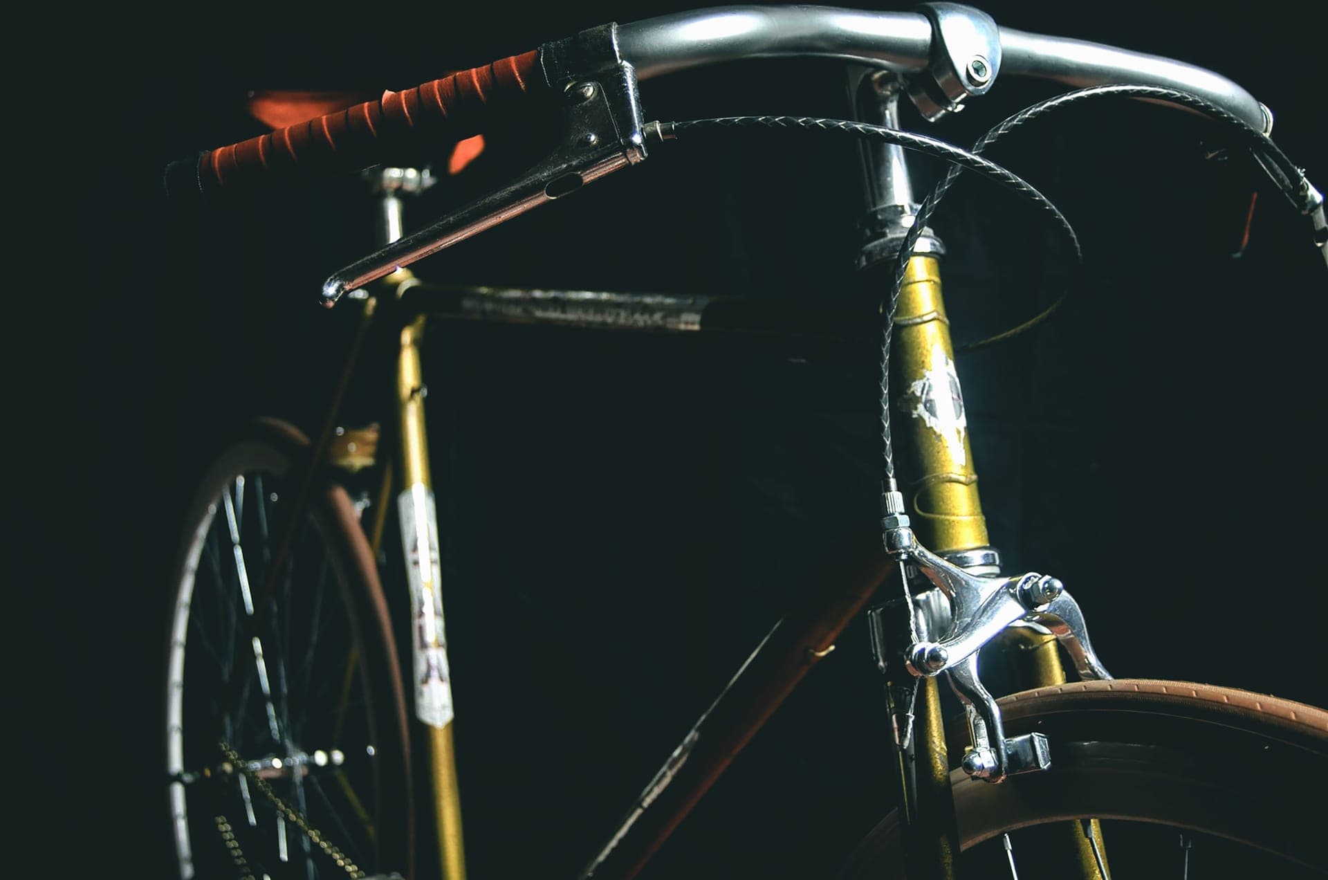 A vintage road bike lit against a black background.