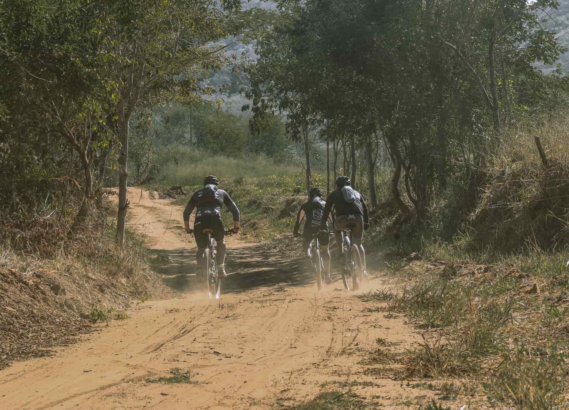 A gravel bike on a dusty fire road in hard afternoon light.